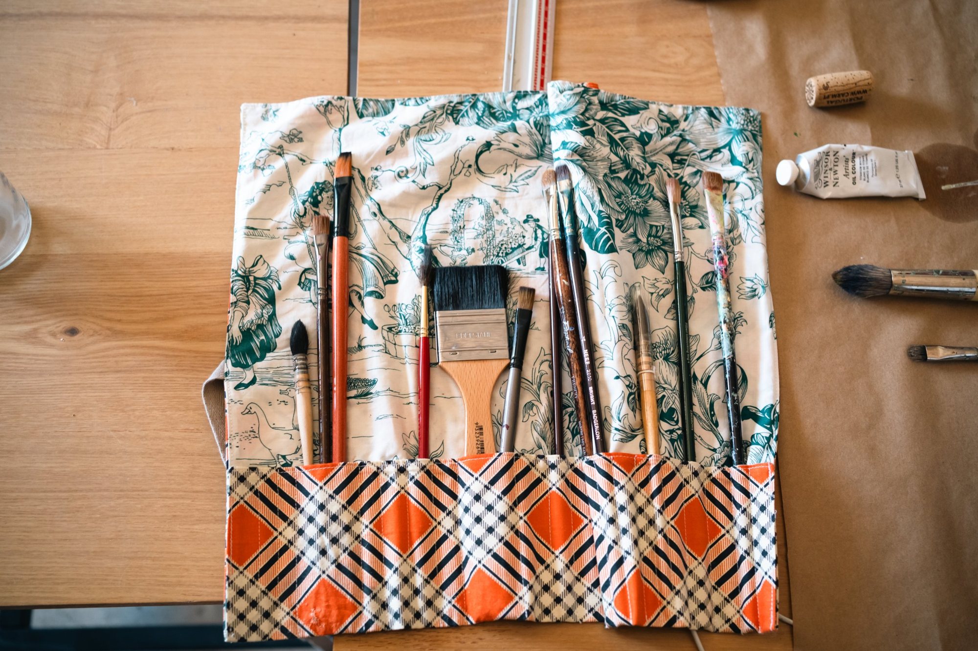 Brush roll with paint brushes on a studio table